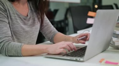 Office bir dizüstü bilgisayarda yazarak oturan bir Bayan