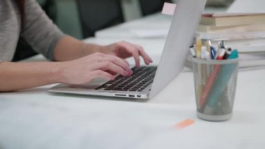 Office bir dizüstü bilgisayarda yazarak oturan bir Bayan