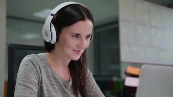 Una joven escuchando música en el portátil — Vídeos de Stock