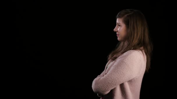 Eine junge Frau lächelt vor schwarzem Hintergrund — Stockvideo