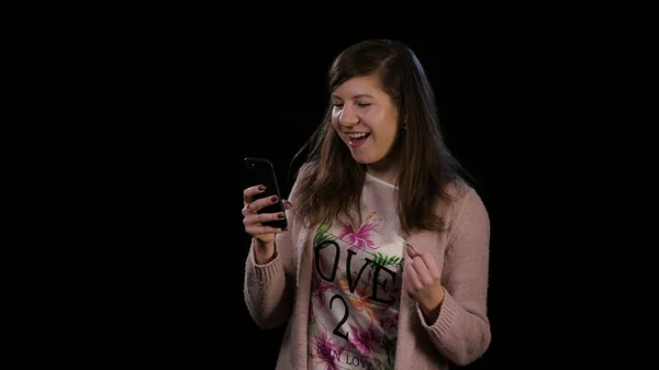 Uma jovem senhora Gesturing Bingo e usando um telefone — Fotografia de Stock