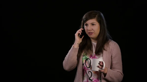 Uma senhora feliz usando telefone contra fundo preto — Fotografia de Stock