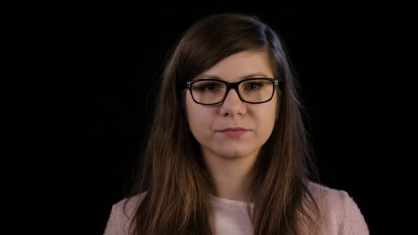 Μια νεαρή κοπέλα με τα γυαλιά που κοιτάζει επίμονα στην κατάπληξη — Αρχείο Βίντεο