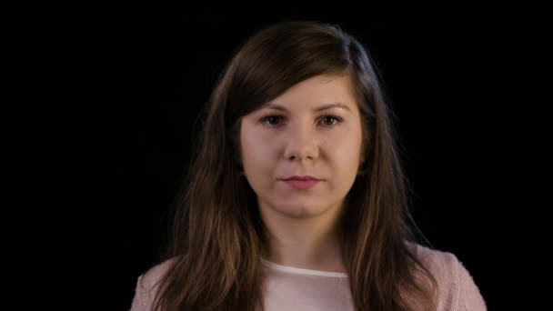 En ung dame smilende mod en sort baggrund – Stock-video