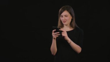 Siyah bir arka plan karşı bir telefonu kullanarak bir Bayan