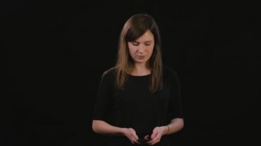 Siyah bir arka plan karşı bir telefonu kullanarak bir Bayan