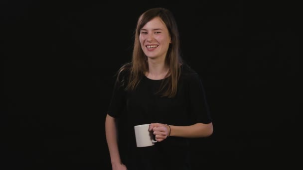 Uma senhora segurando uma taça contra um fundo preto — Vídeo de Stock