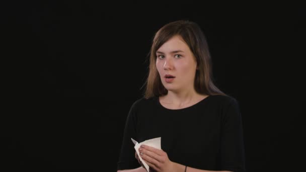 A Lady Blowing Her Nose Against a Black Background — Stock Video