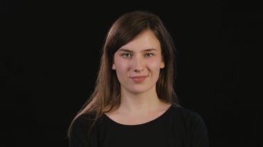 Hanımefendi göndermek siyah bir arka plan karşı gülümseyen yüzü