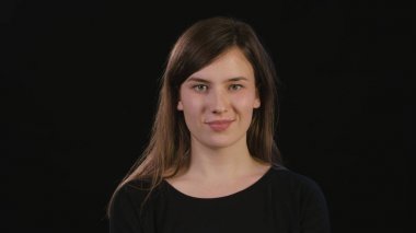 Hanımefendi göndermek siyah bir arka plan karşı gülümseyen yüzü