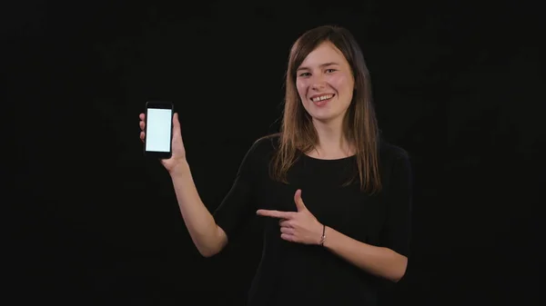 Дівчина використовує телефон на чорному тлі — стокове фото