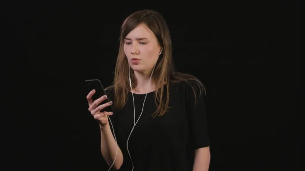Siyah bir arka plan müzik dinlemek bir Bayan