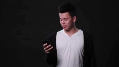 Siyah bir arka plan karşı bir telefonu kullanarak bir adam