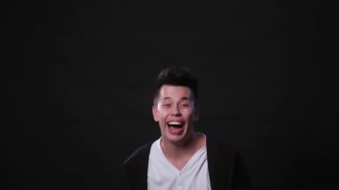 Bir genç adam Mimicing siyah bir arka plan