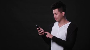 Siyah bir arka plan karşı bir telefonu kullanarak bir adam