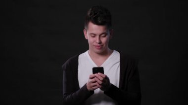 Siyah bir arka plan karşı bir telefonu kullanarak bir adam