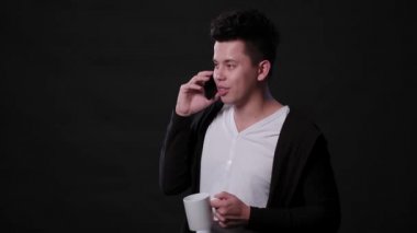 Siyah bir arka plan karşı bir telefonu kullanarak bir adam