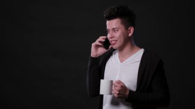 Siyah bir arka plan karşı bir telefonu kullanarak bir adam