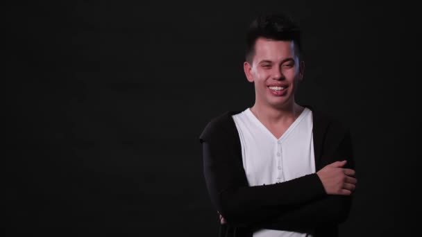 Ein junger Mann mimt vor schwarzem Hintergrund — Stockvideo