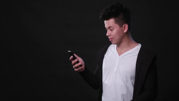 Людина використовує телефон на чорному тлі — стокове відео