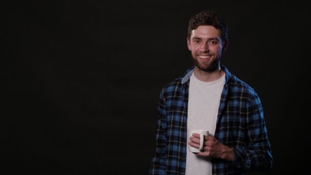 Un hombre sosteniendo una copa blanca contra un fondo negro — Vídeos de Stock