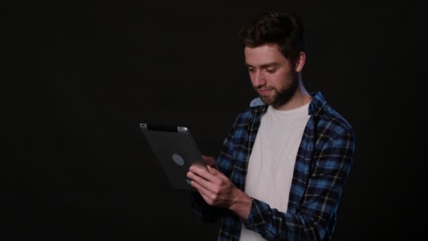 Mann chattet online vor schwarzem Hintergrund — Stockvideo