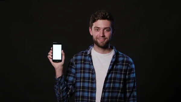 Muž, který držel telefon na černém pozadí — Stock fotografie