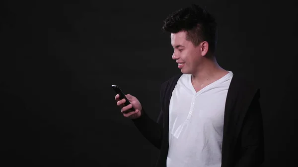 Siyah bir arka plan karşı bir telefonu kullanarak bir adam