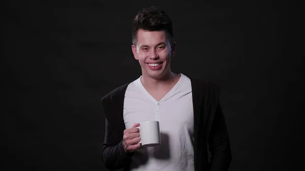 A Man Holding a Cup Against a Black Background — Stock Photo, Image