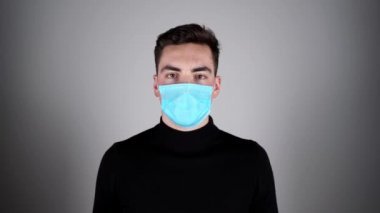  Adam koruyucu maskeyi çıkarıyor. Koruyucu ölçüler. Coronavirus covid-19 sosyal mesafesi. Beyaz adam koruyucu maskeyi çıkarırken önüne bakıyor.