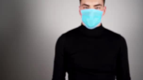 戴着医疗面罩和手套的男人拿着一包起泡的药丸 — 图库视频影像