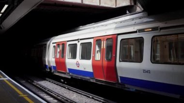 Londra / İngiltere - 05 / 08 / 2020: Londra 'nın işlek bölgesi, COVID-19 koronavirüs salgını sırasında insanların kendini tecrit ettiği popüler bir yer. Sloane Meydanı istasyonuna giden tren. 