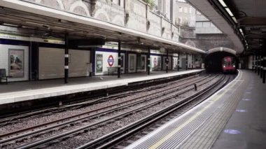 Londra / İngiltere - 05 / 08 / 2020: Londra 'nın işlek bölgesi, COVID-19 koronavirüs salgını sırasında insanların kendini tecrit ettiği popüler bir yer. Sloane Meydanı istasyonuna tren geliyor. 