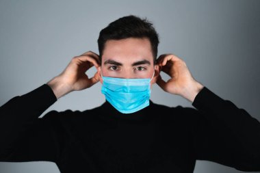 Önünde elinde tıbbi maske olan bir adam. Tıbbi konsept.