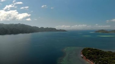 Turkuaz tropik lagünün havadan görünüşü. Filipinler, Palawan, Coron Adası 'ndaki küçük bir köyün üzerinde uçuyorlar. UNESCO Dünya Mirasları Geçici Listesi