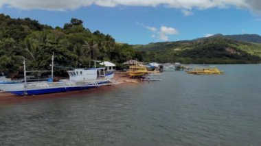 Turkuaz tropik lagünün havadan görünüşü. Filipinler, Palawan, Coron Adası 'ndaki küçük bir köyün üzerinde uçuyorlar. UNESCO Dünya Mirasları Geçici Listesi