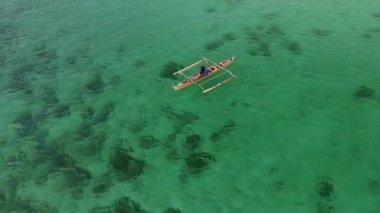 Filipinler, Cebu 'daki Bantaya adasının yanındaki balıkçı teknesinin üzerinde uçuyor.