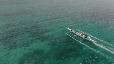 Filipinler, Cebu 'daki Bantaya adasının yanındaki balıkçı teknesinin üzerinde uçuyor.