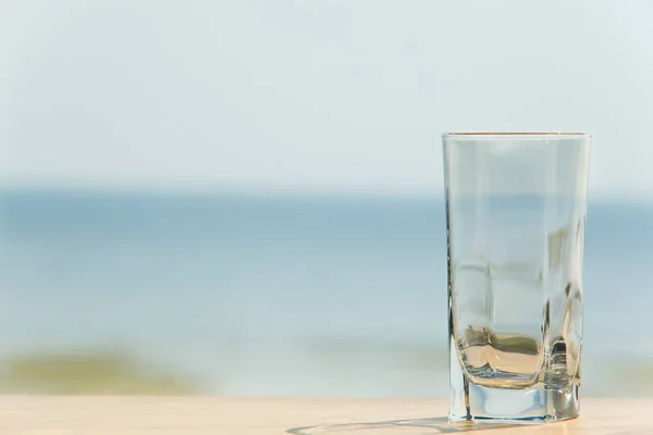 Lege glazen op tafel met de zee op de achtergrond. — Stockfoto