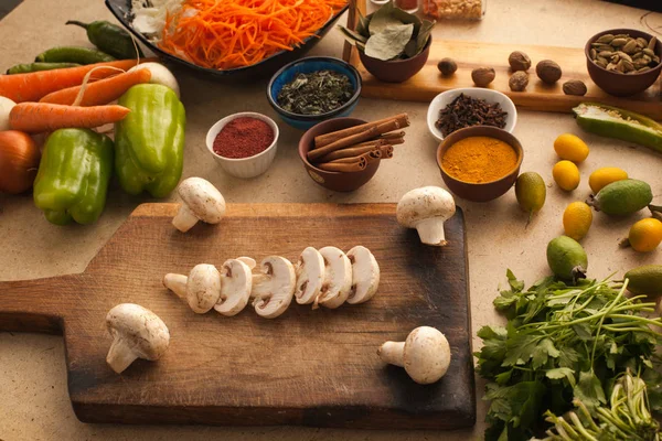 Ahşap masa yemek pişirmek için sebzeli mantar dilimlenmiş. O
