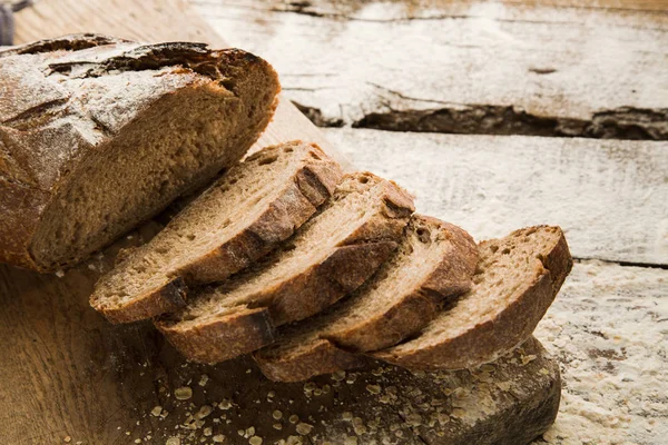 Sliced homemade brown bread on a cutting board. — Stock Photo, Image