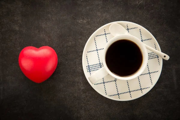 Kahve koyu arka plan üzerinde kırmızı kalpli. — Stok fotoğraf