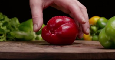 Chef slicing red pepper to cook vegetarian salad.