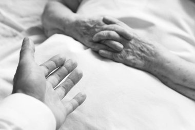 Eski bir kişinin elini tutmaya çalışırken