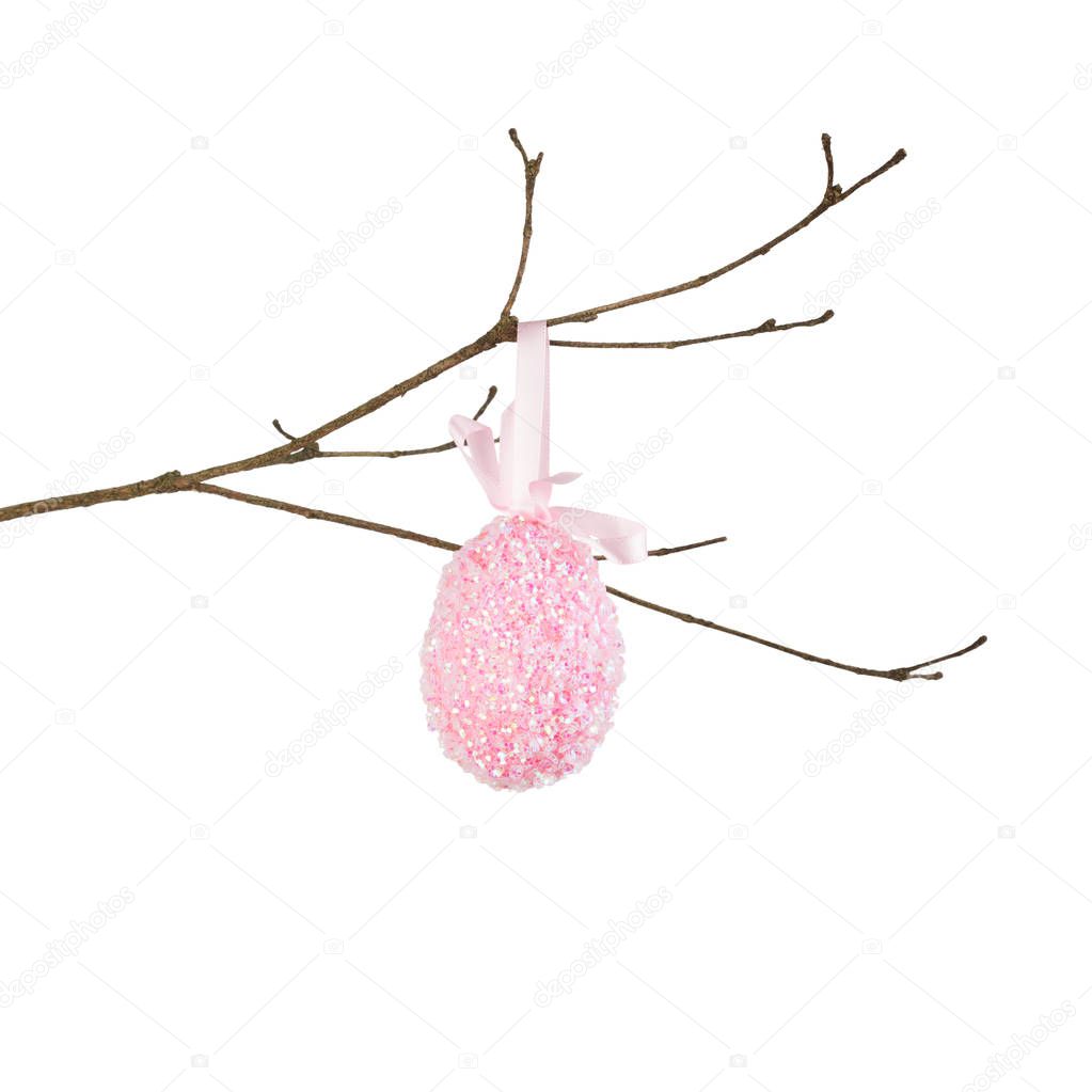 Decorative pink Easter egg hanging on branch