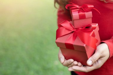 Kadın elleri hediye kutusunu tutuyor. Siyah pakette güzel kırmızı kurdele var. Fotokopi alanı ile sürpriz özel etkinlik için. Noel, doğum günü ya da yeni yıl konsepti. Yüksek çözünürlüklü ürün.