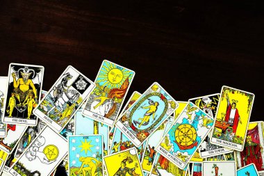 Tahta bir arka plandan esinlenilmiş, dağınık ve gelişigüzel düzenlenmiş bir Tarot kartlı çingene destesi. Falcı, sihirbaz, büyücü. Yıldız falı