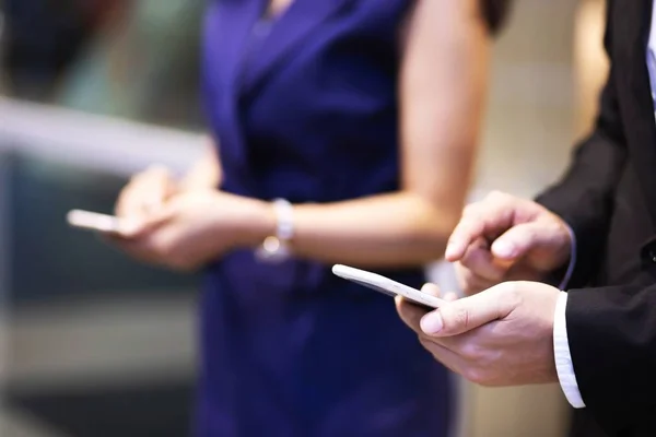 close up hand of Business man using text mobile smart phone holding device and touching screen. or Contact Customer. on standing on background of light in building.