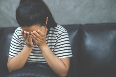 Hüzünlü insanlar, baş ağrısı çekerken alnını tutan mutsuz kadın semptomları sırasında telefonla konuşan bir telefonla koltukta otururlar ve kötü haber mesajı alırlar..