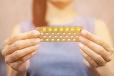 jonge vrouw houdt geboortebeperking pillengenç kadın doğum kontrol hapları tutar